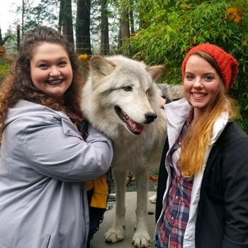 Lanita and Jessika posing for a photo with a dog.