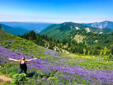 A woman standing in a field of purple flowers.