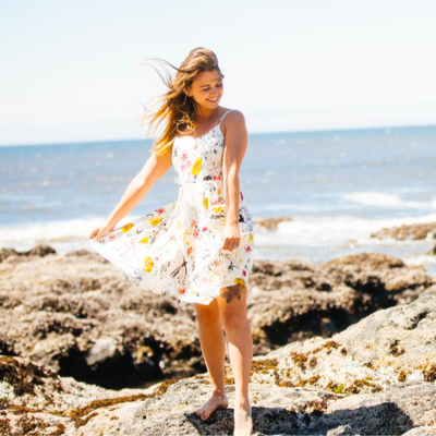 Heather standing in front of a beach.