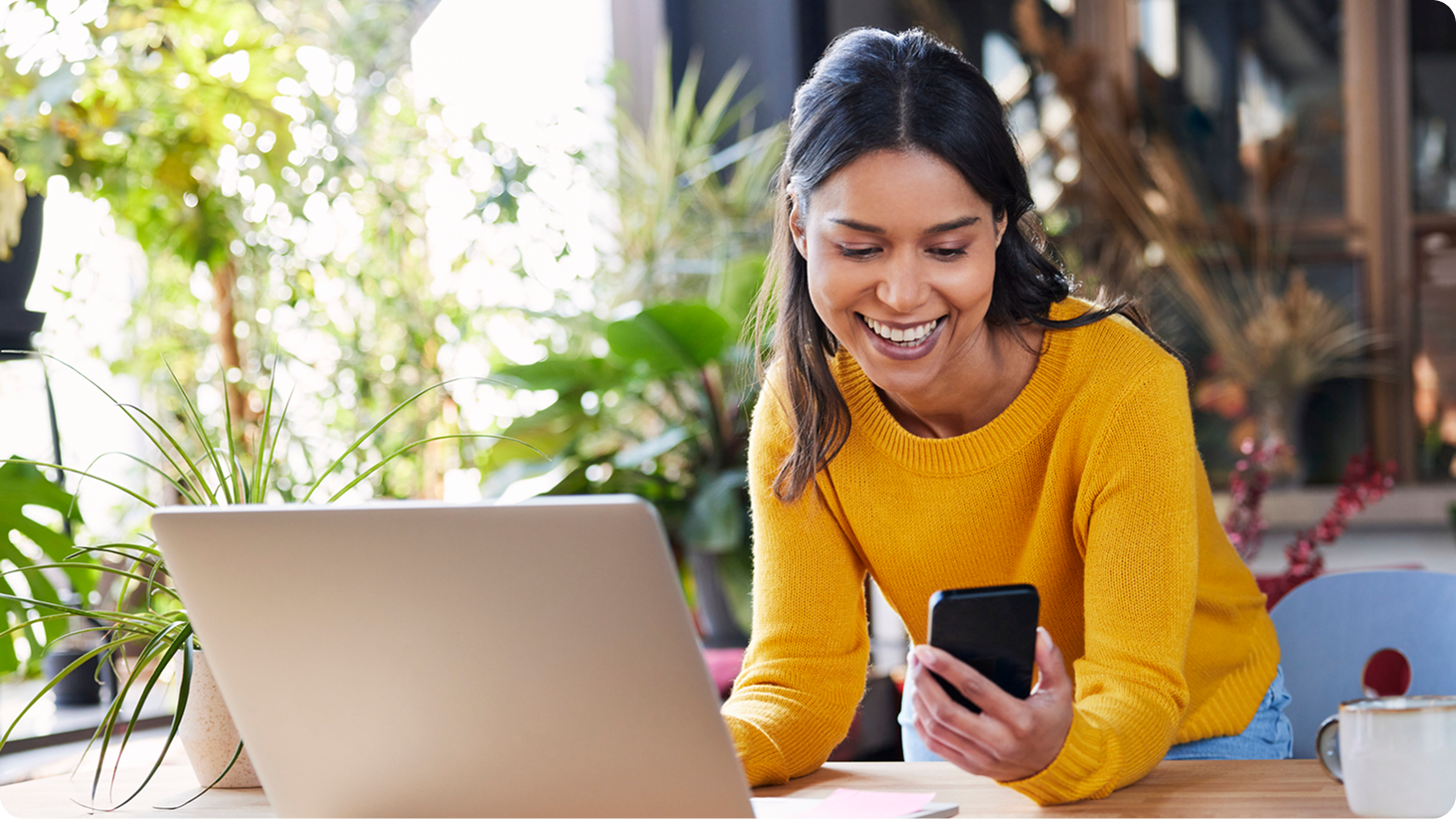 Female holding phone while working on laptop