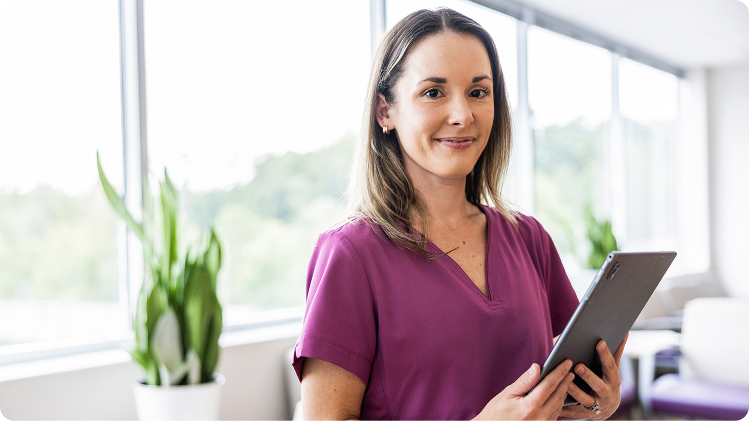 Female holding phone while working on laptop